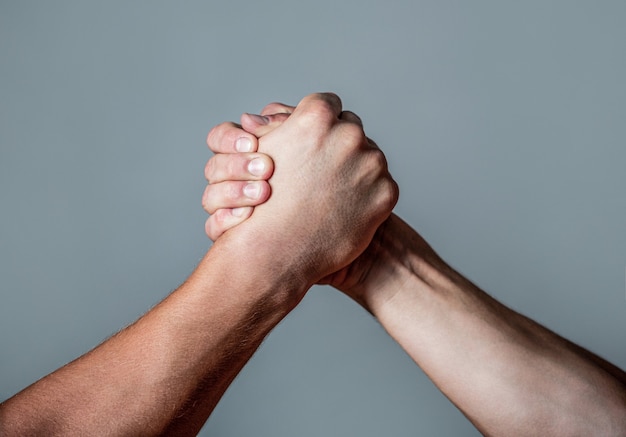 Man hand. Twee mannen armworstelen. Armen worstelen. Dichtbij. Vriendelijke handdruk, groeten van vrienden, teamwerk, vriendschap. Handdruk, armen