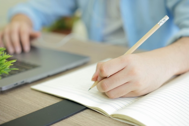 새로운 정상적인 라이프 스타일 개념을 배우기위한 숙제 또는 연습 시험을 작성하는 연필을 사용하는 사람 손