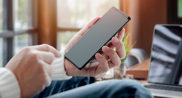 Man hand using smartphone working from home.