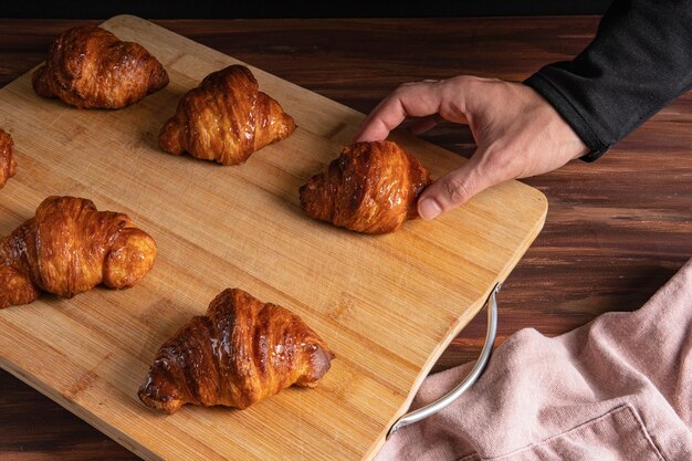 Foto mano dell'uomo con due dita per scegliere un dessert di pasta sfoglia, da vicino