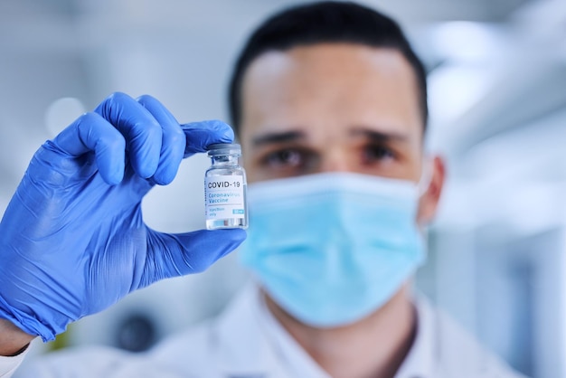 Man hand and vaccine bottle in hospital for treatment or illness control for virus disease and innovation Male medical worker booster and shot for immunization prevention and cure for covid 19