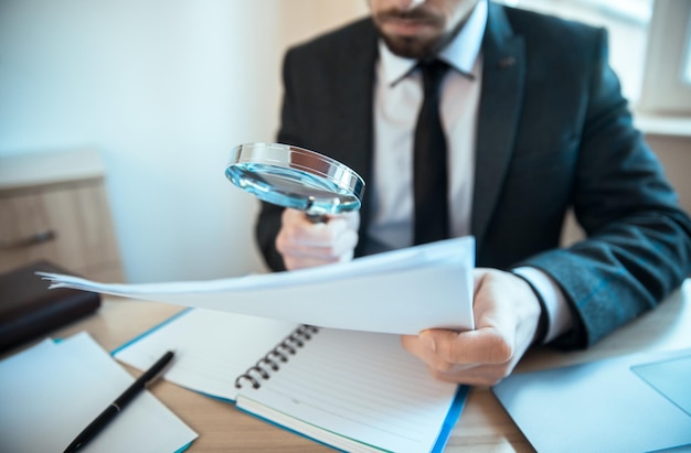 Man hand vergrootglas en document