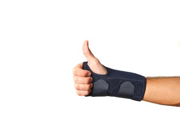 Man hand with therapeutic wrist brace to relieve wrist sprain pain with thumb up