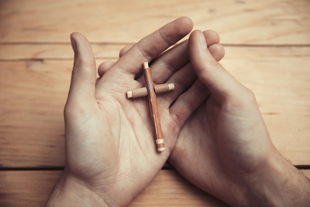 Photo man hand wooden cross