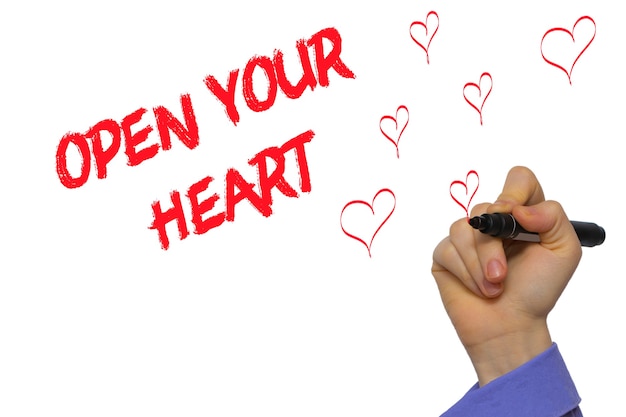 Man Hand writing Open your heart with marker on transparent wipe board. Isolated on white.