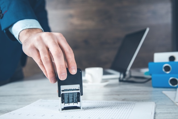 Man hand zegel met document in bureau