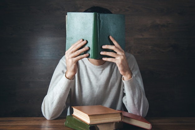 Man handboek in gezicht op tafel