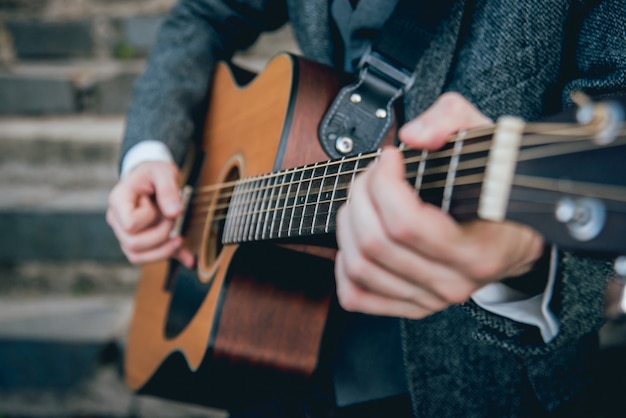 Man handen die akoestische gitaar spelen. authentieke achtergrond.