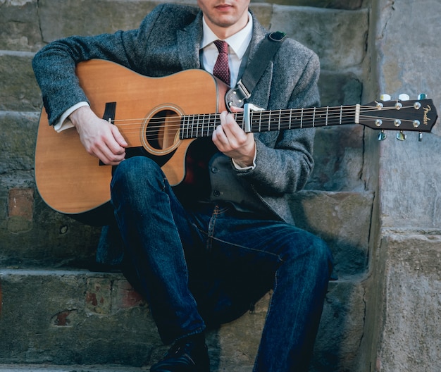 Man handen die akoestische gitaar spelen. Authentieke achtergrond.