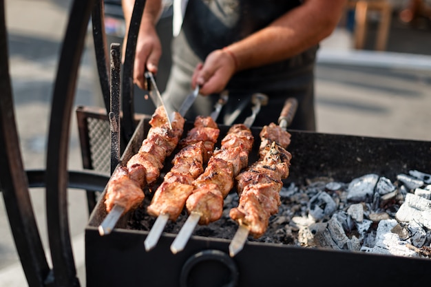 Man handen koken vlees op een barbecue