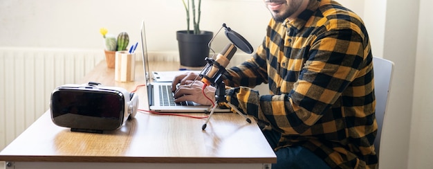 Man handen typen op een computer tijdens het opnemen van een podcast