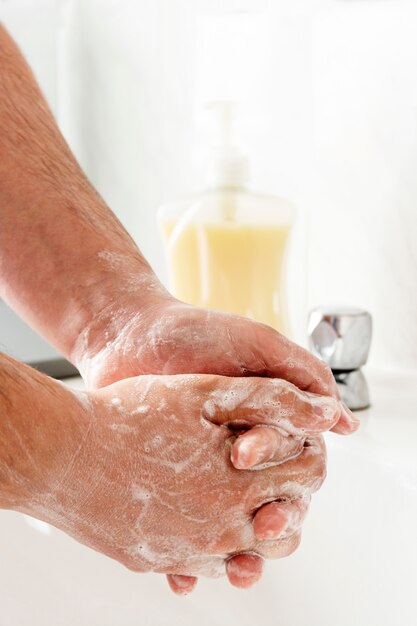 Man handen wassen zijn handen over gootsteen in badkamers.