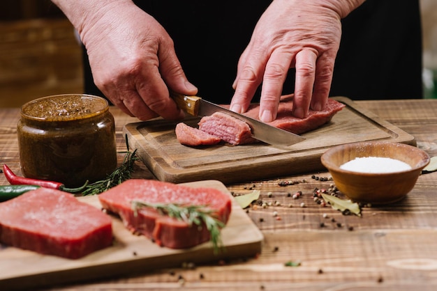 Man hands chop fresh raw meat steaks close up