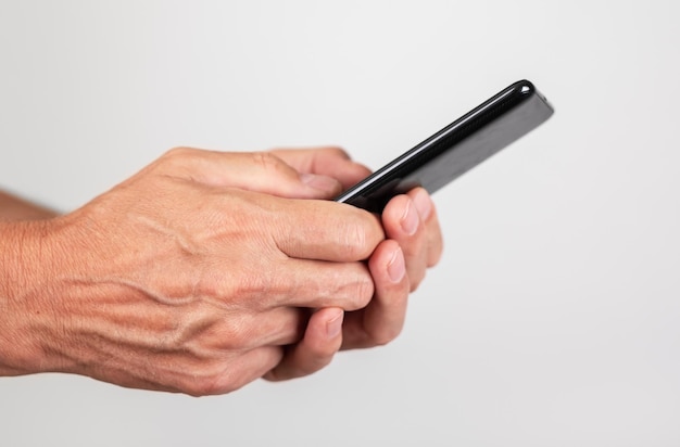 Man hands closeup texting message at phone Male using messenger or searching information on Internet