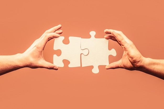 Photo man hands connecting couple puzzle piece. business solutions, target, success, goals and strategy concepts. hand connecting jigsaw puzzle. business solutions, success and strategy concept.