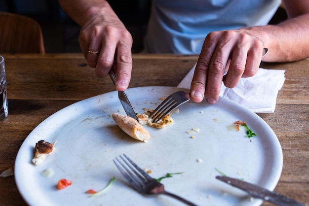 写真 ピザの空の皿を食べる男の手