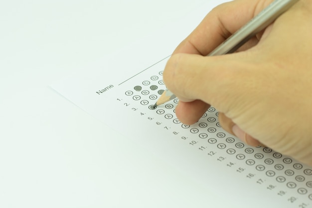 man hands filling in standardized test form