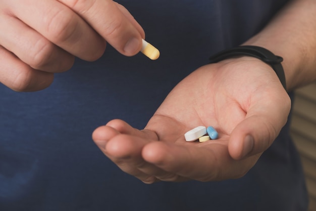 Photo man hands hold different pills