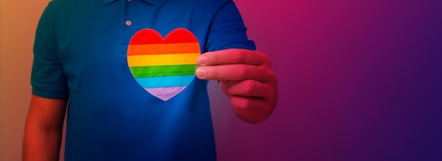 男の手は虹の色で心を保持します LGBT の権利プライド月間の寛容と愛のコンセプト