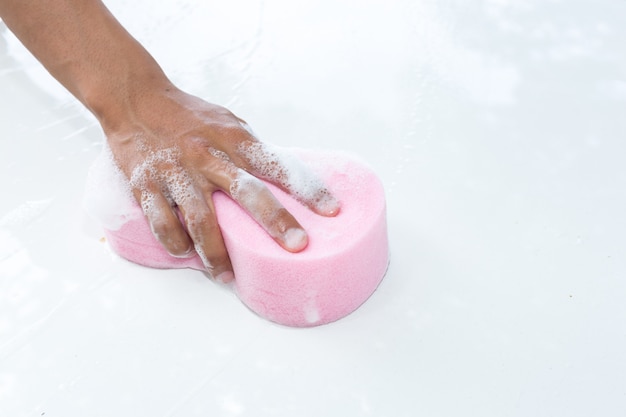 Man hands hold sponge for washing  white car