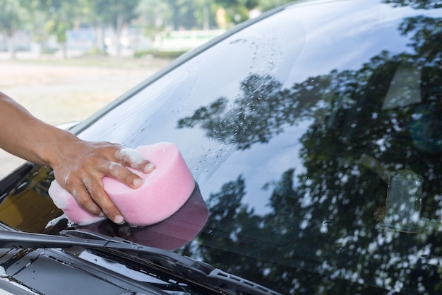 Man hands hold sponge for washing  white car