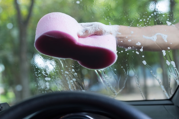 Man hands hold sponge for washing  white car