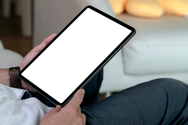 man hands holding blank screen tablet while sitting at home