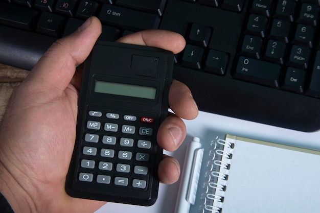 Man hands holding calculator with wood background