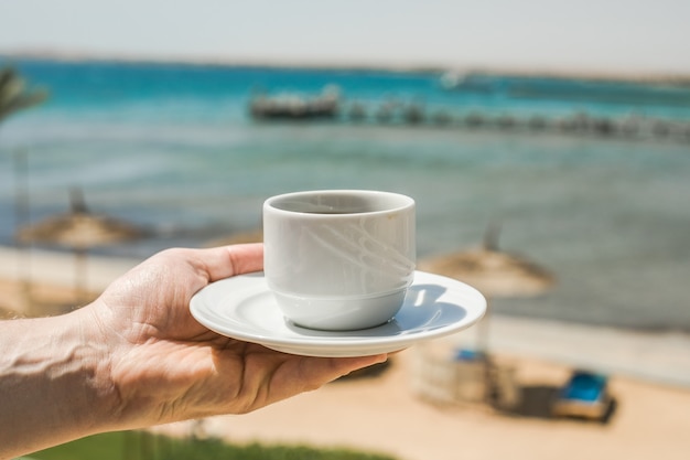 一杯のコーヒーを保持している男の手