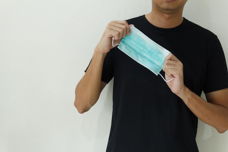 Photo 医療用保護マスクを握る男性の手
