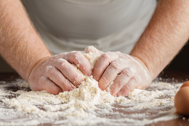 Man hands kneading a dough