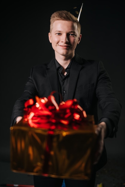 Man hands offer to take a gift in a colorful holiday package closeup