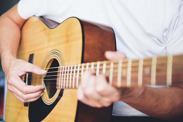 Man hands playing acoustic guitar, close up guitar player