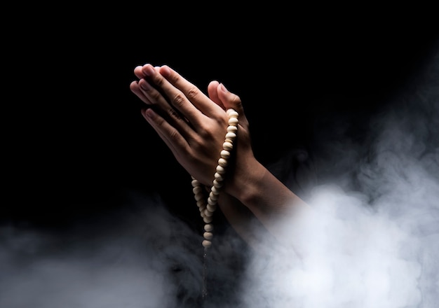 Man hands praying with prayer beads