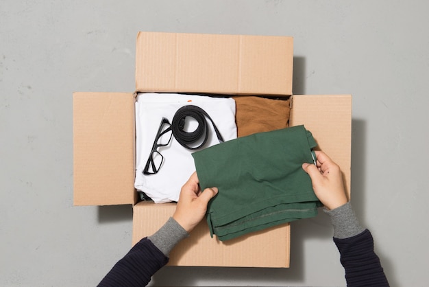 Man hands putting clothes to donate box