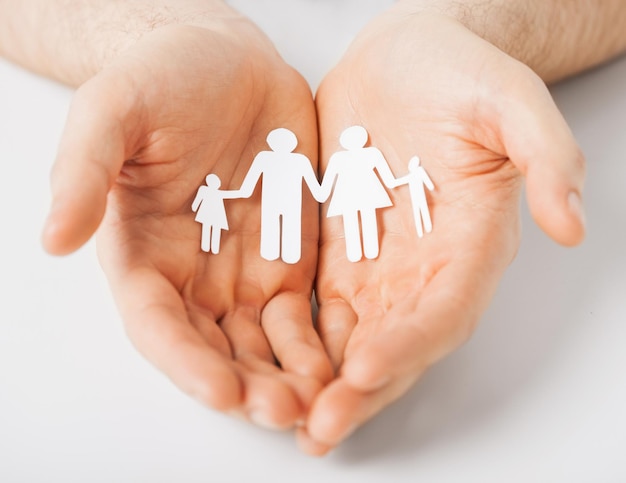 Photo man hands showing family of paper men