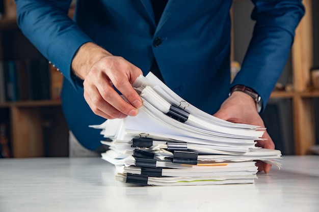 Photo man hands stacks documents of paper files