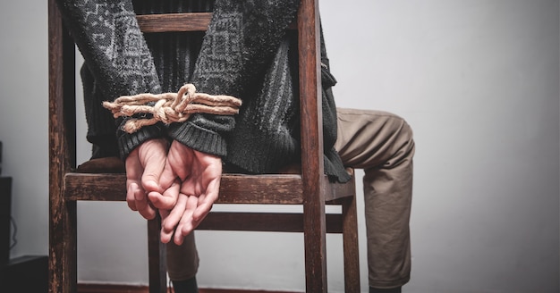 Man hands tied by a rope. Imprisonment