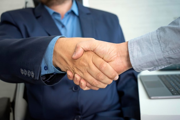 Man handshake with hr manager after job interview in office Attractive male employee shake hands with human resources manager businessman after apply recruit and hire workplace