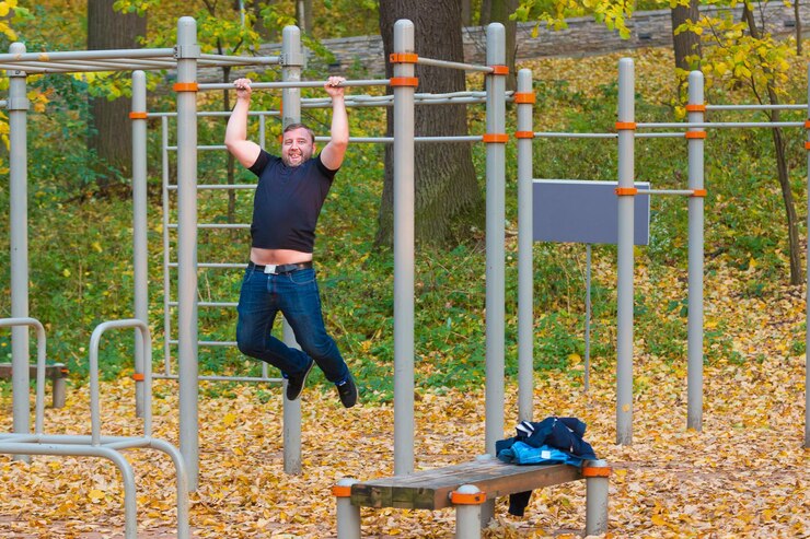 Photo man hanging on outdoor play equipment in park