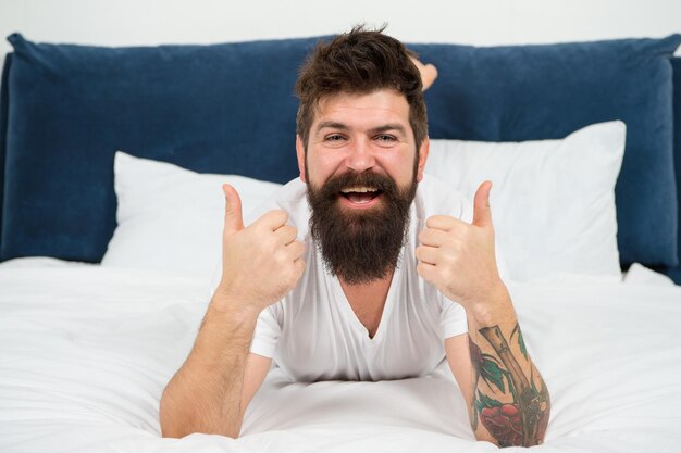 Man happy bearded face relax on bed at home soft mattress concept