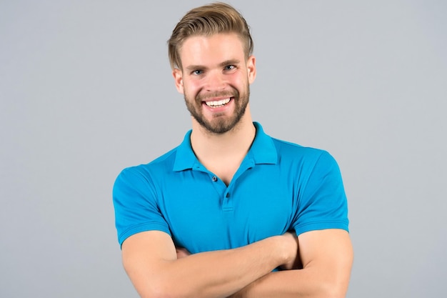 Man happy smile in blue tshirt, fashion. Man with bearded face, blond hair, haircut.