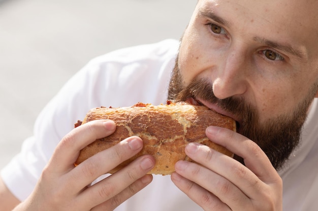 男は昼食をとります。彼は自分のサンドイッチを見て、すぐに食べようとしています。