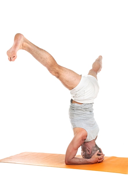 man and hatha yoga asana in front of white background