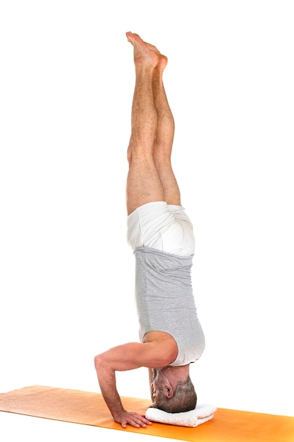 man and hatha yoga asana in front of white background