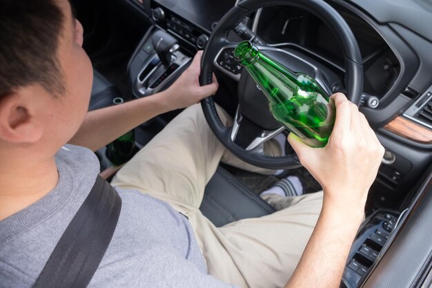 写真 車の中でビールを飲んでいる男