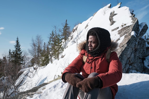 Man having break wile hiking to mountain top