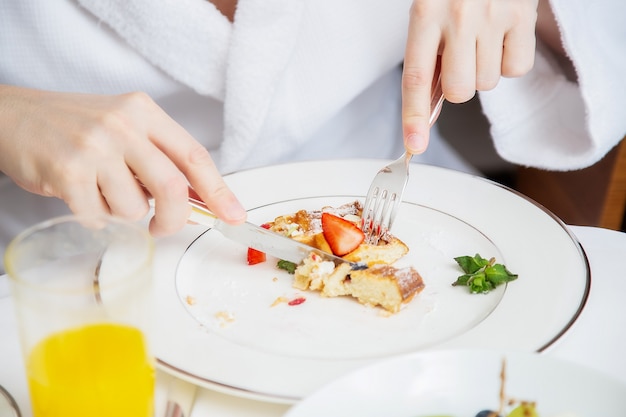 新鮮なベリーと揚げワッフルの朝食を食べている男