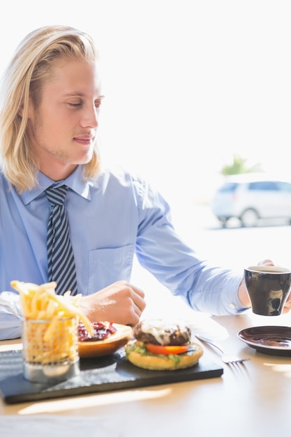 コーヒーと朝食を持っている人