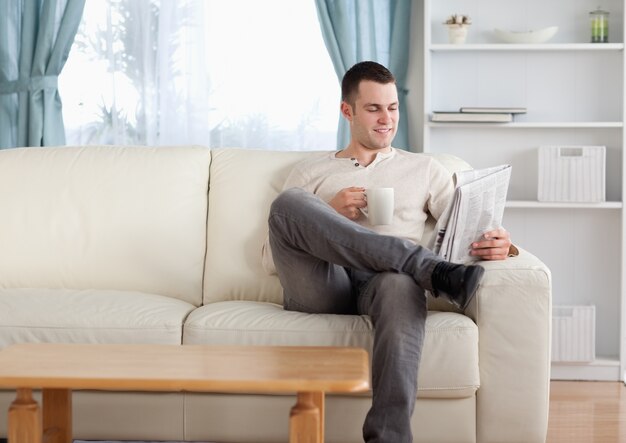 ニュースを読んでいる間コーヒーを飲んでいる男